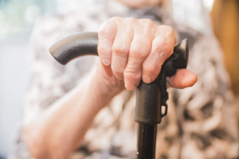 Une personne agée prenant appui sur une canne